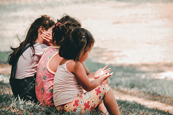 3 little girls sitting in the grass together