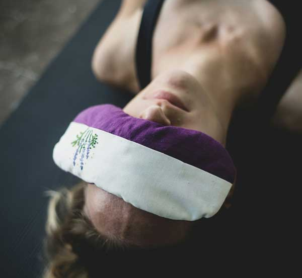 a woman laying down and relaxing with an eye mask