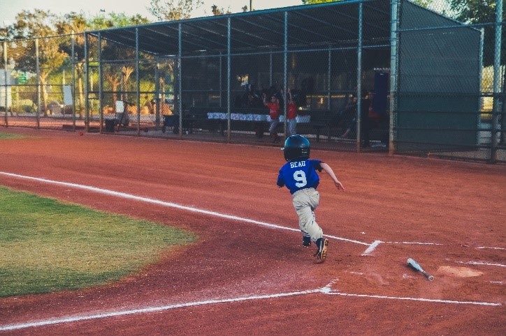 A child running to first base during a baseball game