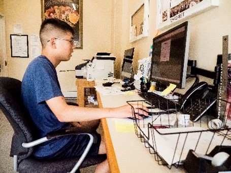 A teen sitting in front of a computer