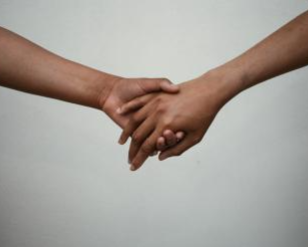 close up of 2 people holding hands
