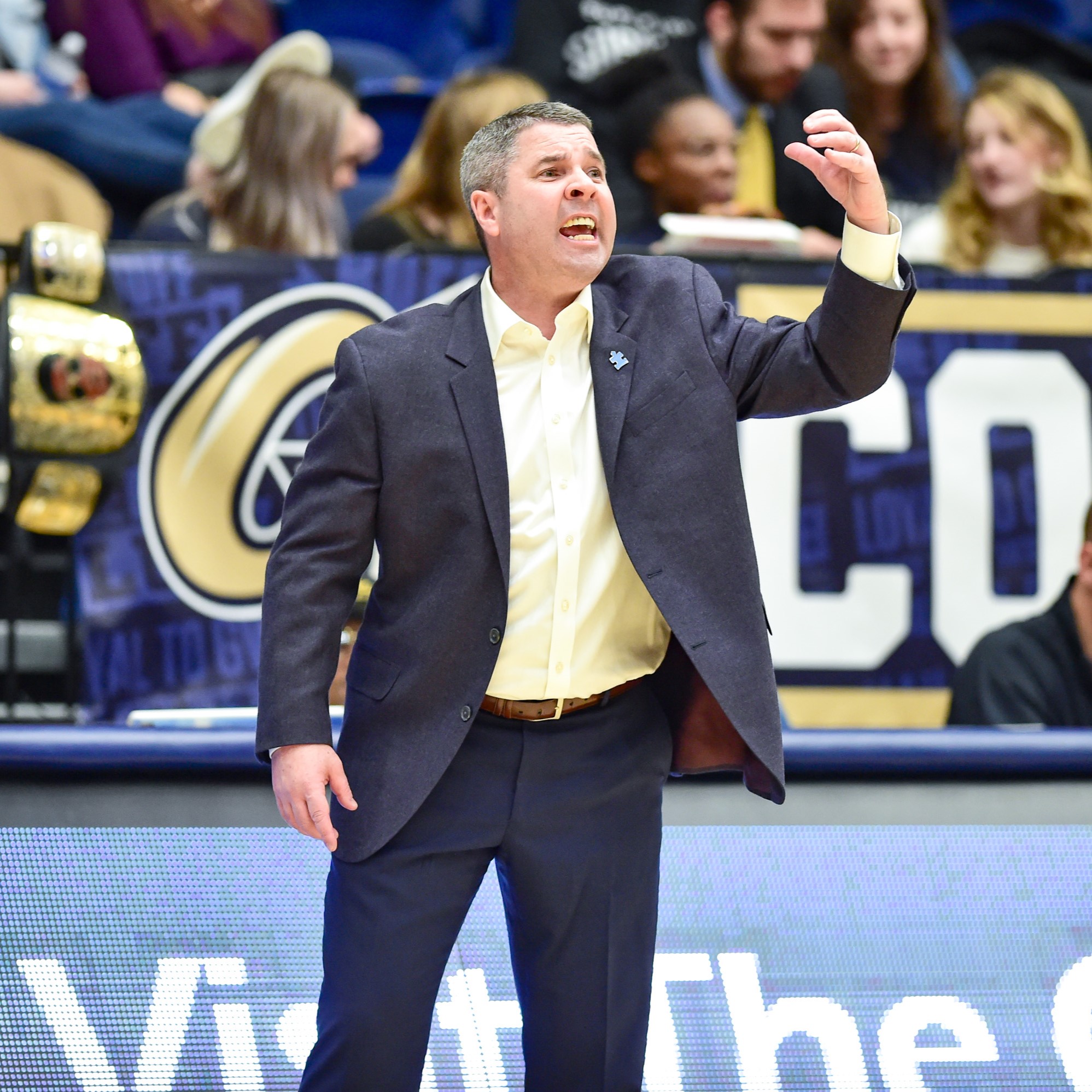 Basketball coach wearing an Autism Speaks pin during a game