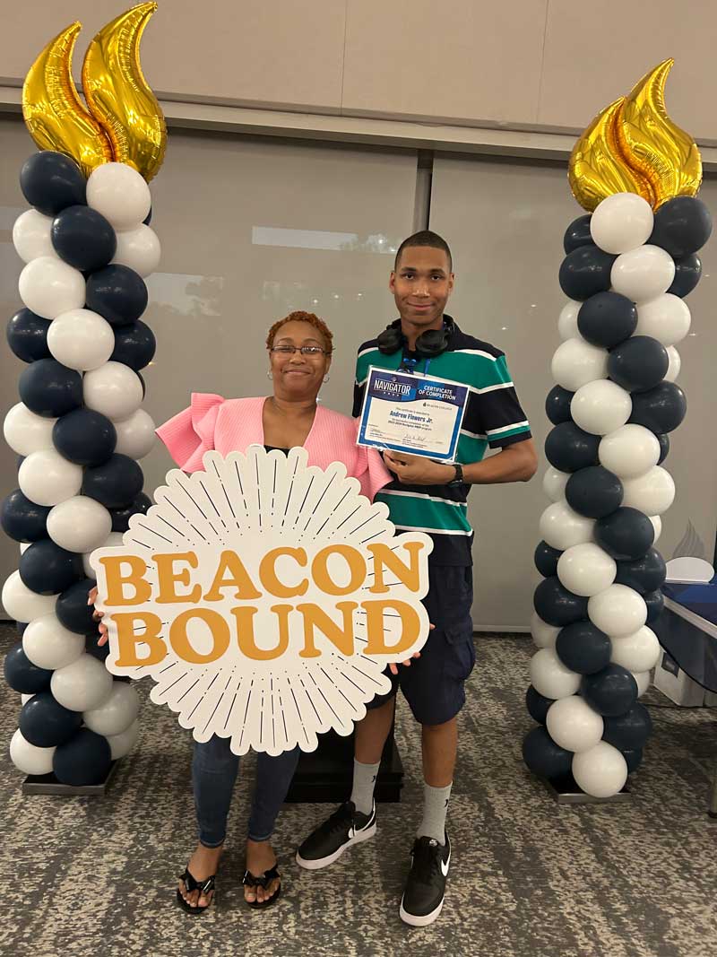 DJ and his mom holding a sign that says 'Beacon Bound'