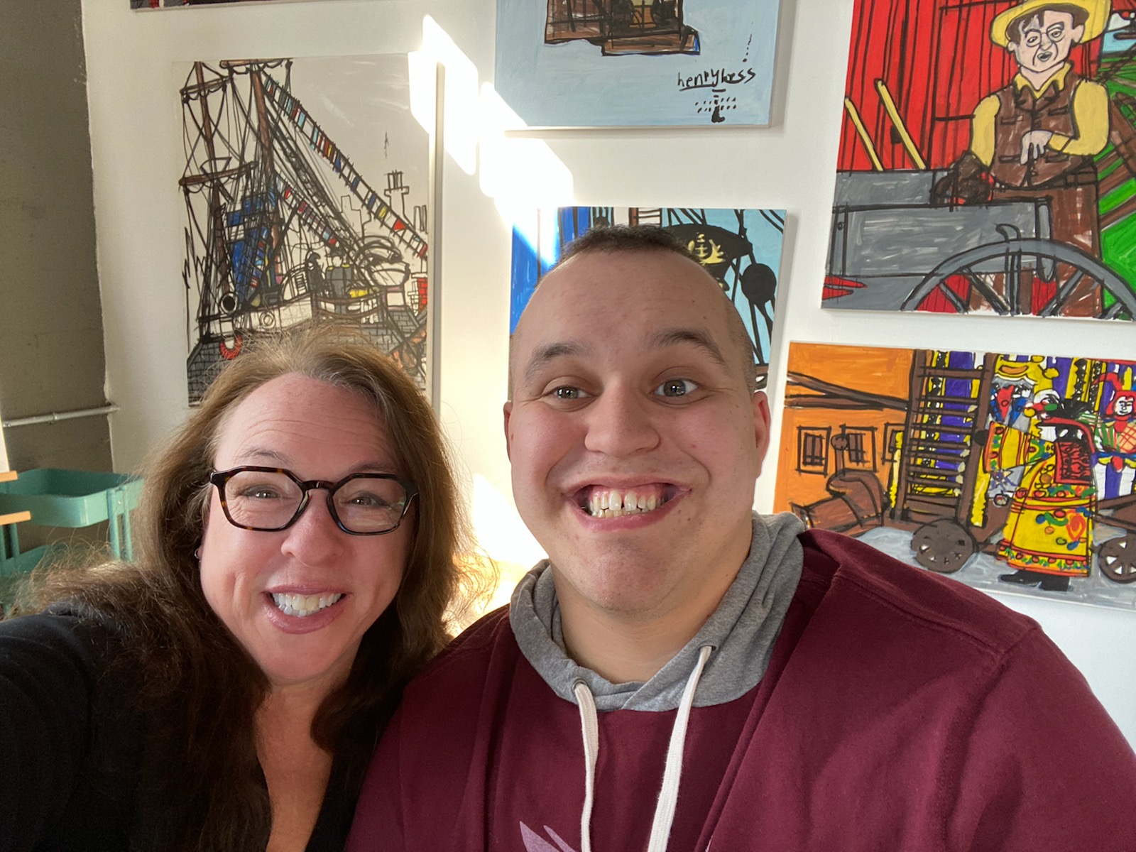 A woman and man smiling in an art gallery