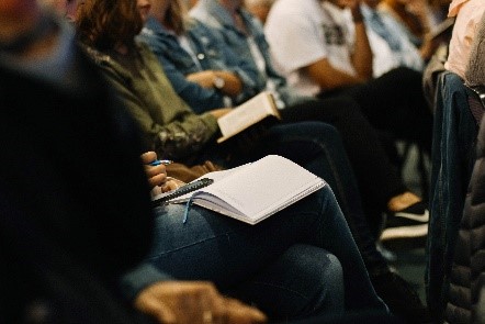 Group of people taking notes as a conference