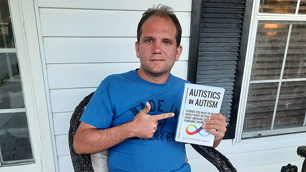 Josh holding a copy of the book 