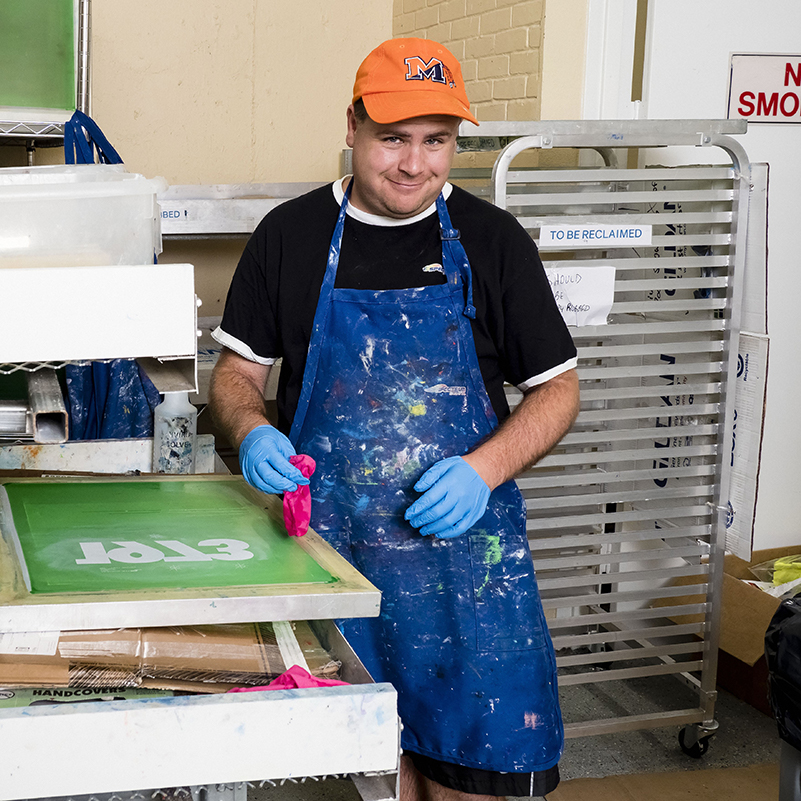 man wearing an apron and hat at work