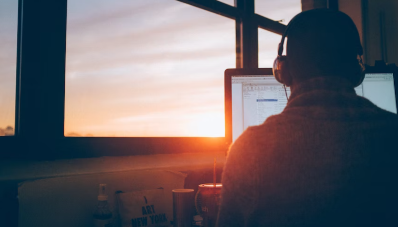 person on a computer wearing headphones