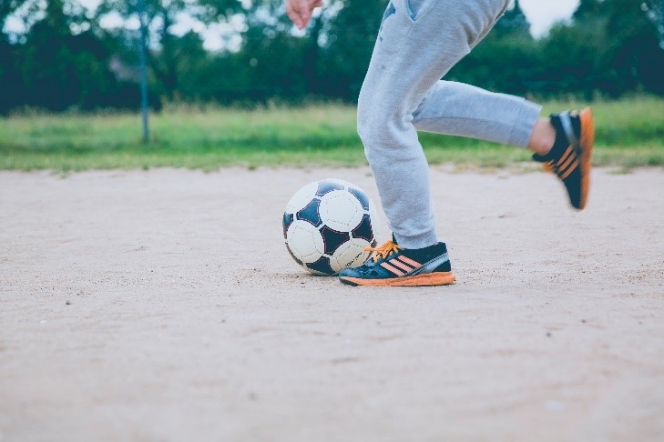 Person running and kicking a soccer ball