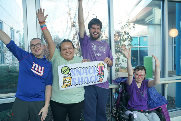 Snack Shack employees smiling with their hands in the air