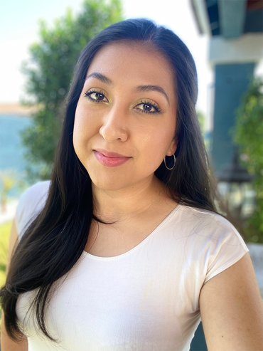 Tania wearing a white shirt and smiling for a selfie