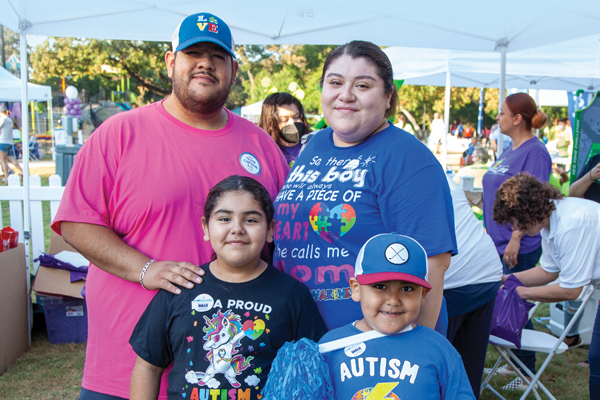 a family of 4 smiling at an Autism Speaks Walk