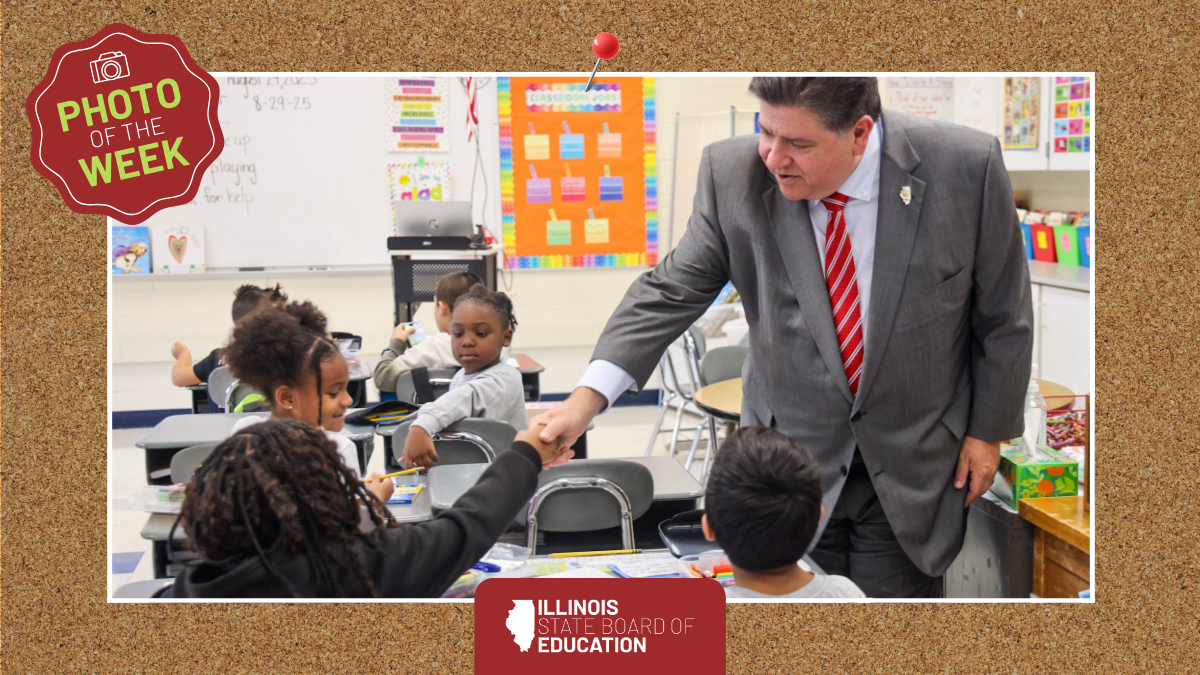 Governor JB Pritzker shakes hands with a student. 