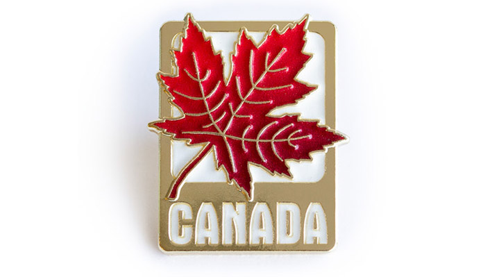 Canada Pin featuring a vibrant red maple leaf layered on top of a sleek gold-toned base with the word Canada.