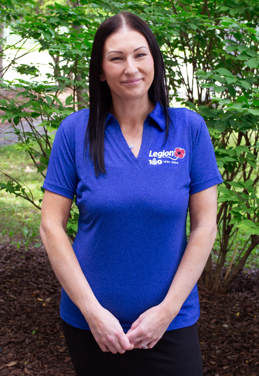 A woman wears a cobalt blue polo shirt with the Legion Centenary logo