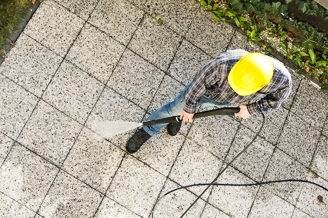 person in a hardhat spraying cement outside